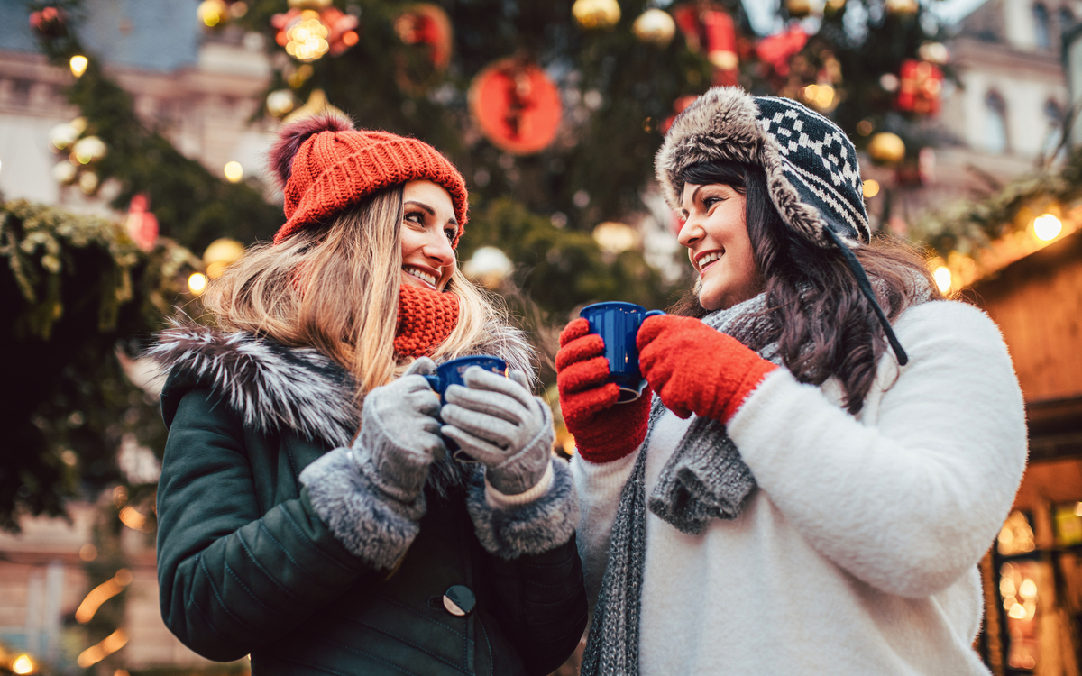 beste Freunde genießen Glühwein auf dem Weihnachtsmarkt - © Kzenon - stock.adobe.com