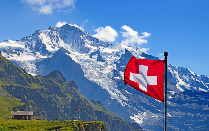 Schweizer Flagge vor dem Berg Jungfrau in der Schweiz - © swisshippo - stock.adobe.com