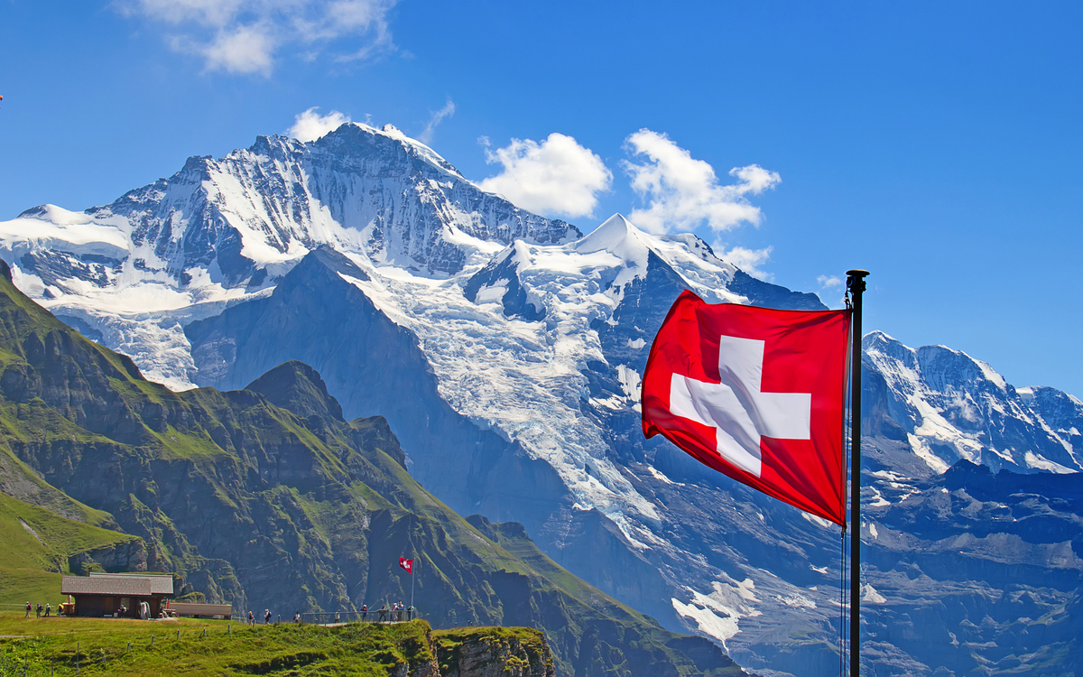 Schweizer Flagge vor dem Berg Jungfrau in der Schweiz - © swisshippo - stock.adobe.com