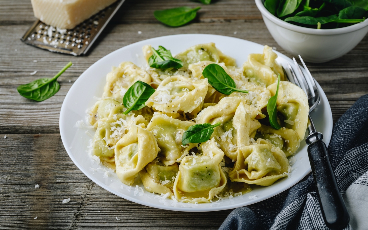 Italienische Ravioli-Nudeln mit Spinat und Ricotta auf Holzuntergrund, - © nblxer - stock.adobe.com