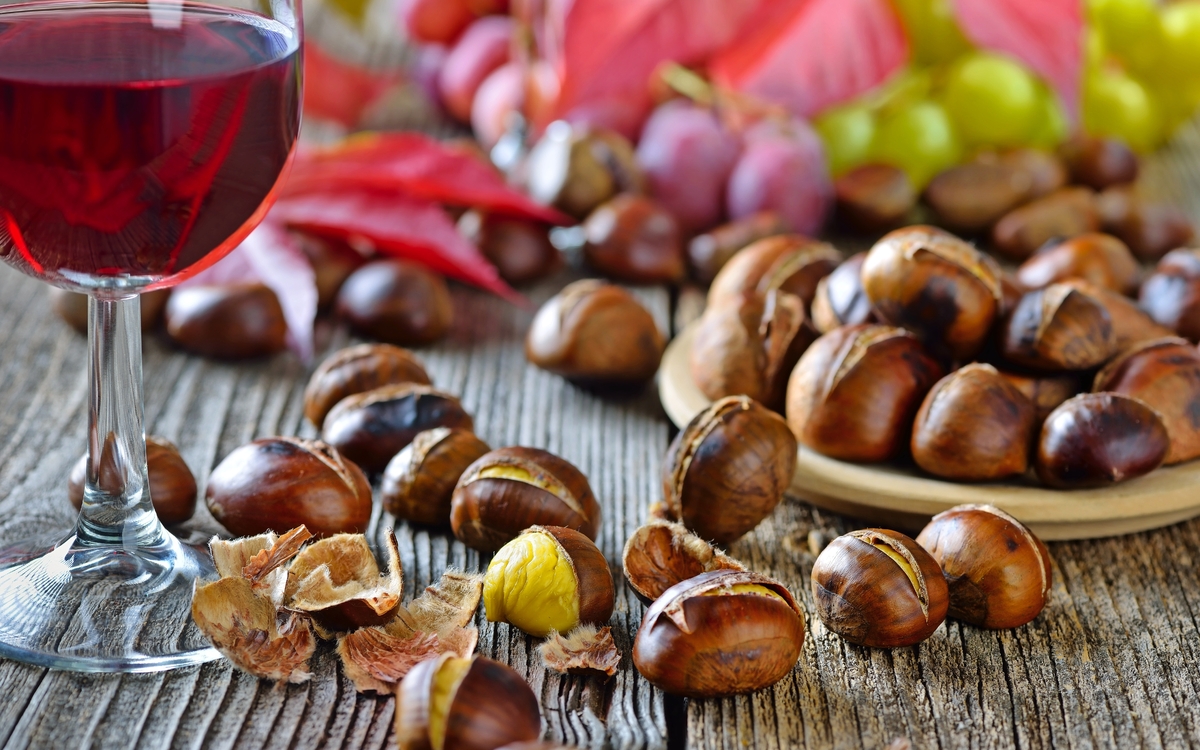 Geröstete Maroni mit neuem Rotwein, weiße und rote Weintrauben im Hintergrund - © kab-vision - stock.adobe.com